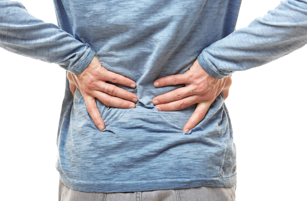 Man suffering from backache on white background, closeup