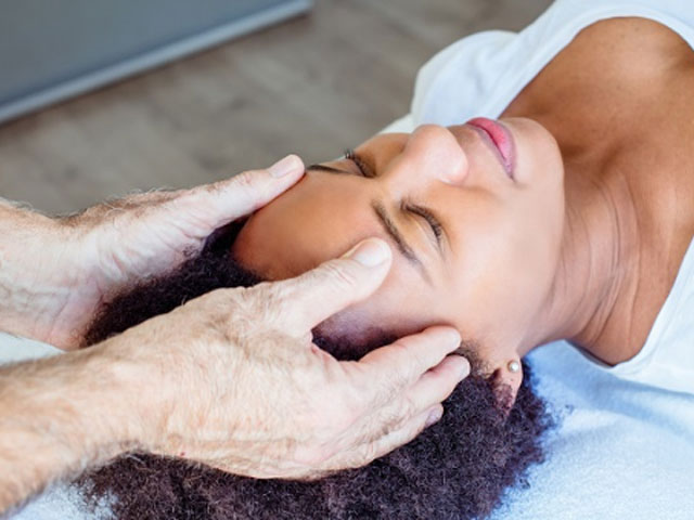 image of a hands giving massaging temples of a female patient.