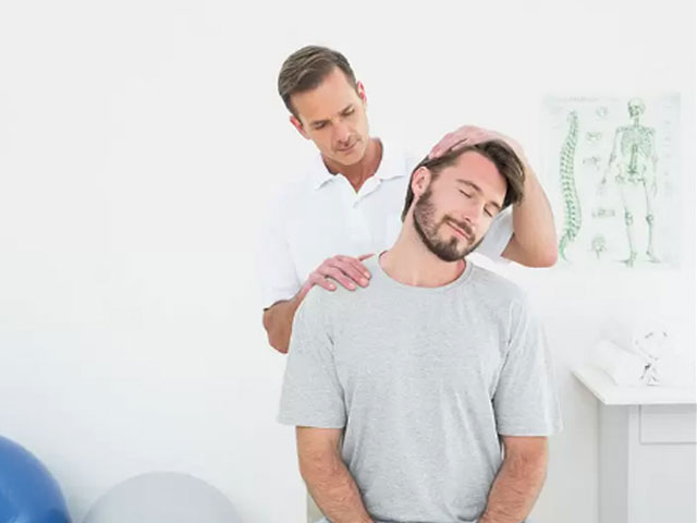 Image of a man having his neck evaluated by a chiropractor